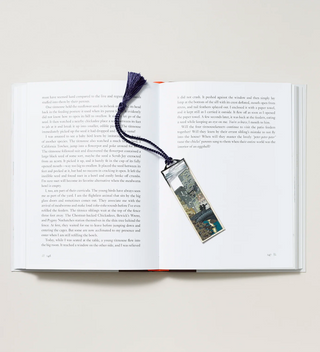 Bookmark with a Central Park design featuring a tassel, placed on an open book.