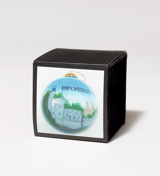 Decorative ornament with a painting of Belvedere Castle in Central Park, displayed in a black velvet box.