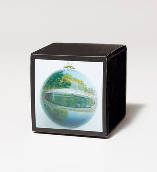 Decorative ornament with a painting of a bridge over a pond in Central Park, displayed in a black velvet box.