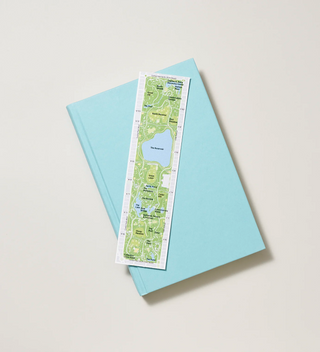 Bookmark with a detailed map of Central Park placed on top of a light blue book.