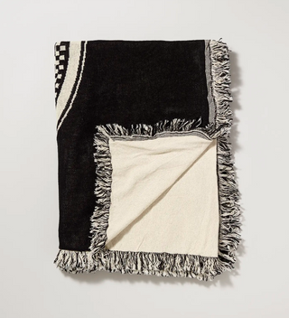 A cream and black blanket folded to show the reverse side 