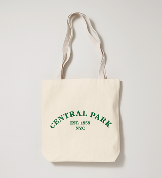 Beige tote bag with the text 'Central Park Est. 1858 NYC' in green ink.