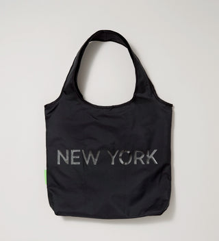 Back view of a black tote bag with "New York" printed on it in dark letters