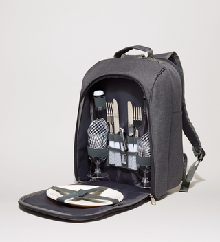 Gray picnic backpack, opened up to show cutlery, plates, glasses, napkins, and salt and pepper shakers attached to the inside