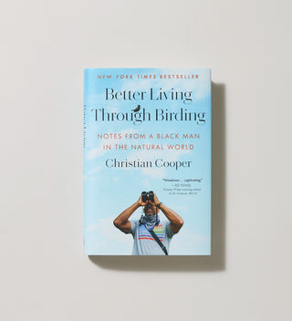 Cover of the book 'Better Living Through Birding' by author Christian Cooper, featuring a man looking through binoculars on a light background.