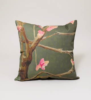 India & Purry square pillow featuring a design of Eastern Redbud in blossoms on a dark green background, front view.