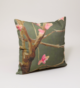 India & Purry square pillow with a design of  Eastern Redbud in blossoms on a dark green background, side view.