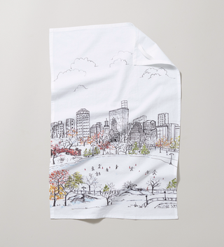 Unfolded flour sack tea towel featuring a scene of ice skaters at Central Park