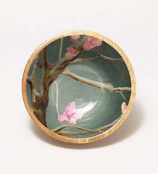 Top view of wooden bowl with a painted flower and branch pattern on the inside