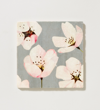 India & Purry trivet featuring cherry blossoms made from marble, 6" square on a gray background.