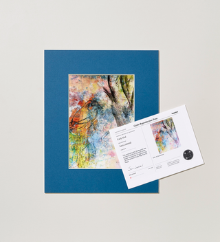 Art print in a blue frame, featuring a bird, a tree branch, and splashes of color throughout, shown alongside a card with information about the piece