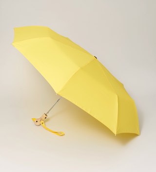 Opened yellow umbrella with a handle that's shaped to look like a duck