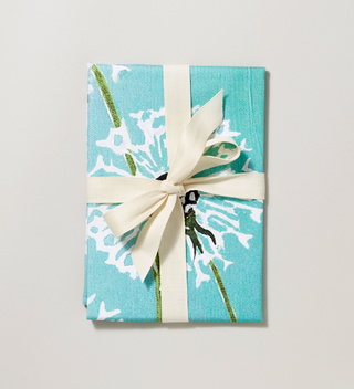 Packaged teal cloth tea towel with white dandelion print
