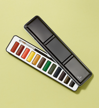 Partially open watercolor set, showing the watercolors and watercolor brush