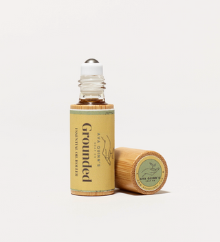 Ava Quinn's "Grounded" essential oil roller opened, with the cap lying nearby