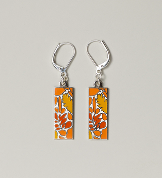 Close-up of orange leaf design pendant earrings with lever-back hooks