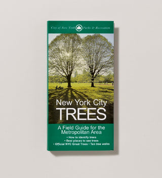 Cover of paperback book titled "New York City TREES" with white text on a green background and a photograph of two trees in a field  in a grey background