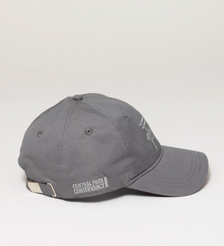 Side view of a gray baseball cap with a Central Park bench embroidered on the front and the Central Park Conservancy logo on the side