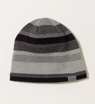 A black and grey knit hat with a grey woven wrap around label reading Central park Est. 1858, NYC on a grey background