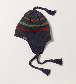 a  flat side-view of a striped navy knit hat with earflaps, top tassel and tassel ties and a woven wrap-around label with 'Central Park Est. 1858, NYC' on a grey background