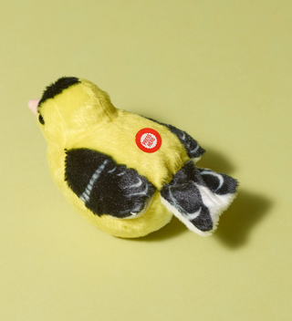 Audubon plush toy, American goldfinch bird in yellow and black colors, featuring a button labeled 'Press Here' on its back to hear an authentic bird call from the Cornell Lab of Ornithology's wildlife recordings