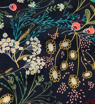 Close up image of Floral Travel Scarf made from lightweight, airy 100% rayon, featuring a multicolor wildflower design on  a navy  blue background.