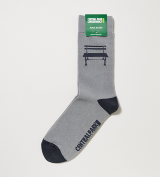 Unfolded gray and black adult socks with a Central Park bench and the Central Park Conservancy logo on them