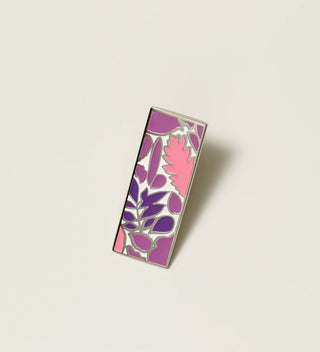 Central Park Conservancy pin with a pink and purple leaf design, displayed on a light grey background