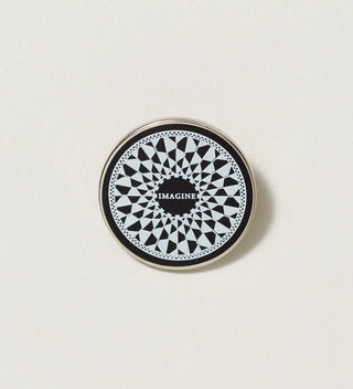 Close-up of a black and white round pin with a mosaic design and the word 'Imagine' in the center, on a white background.