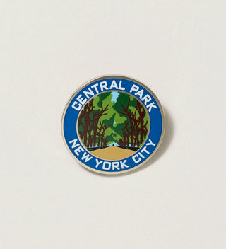 Close-up of a round Central Park pin featuring a path lined with trees and 'Central Park, New York City' text on a white background.