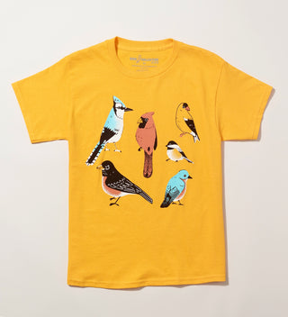 A flat golden yellow t-shirt printed with five birds including a  Blue Jay, Cardinal, Robin, Chickadee and Bluebird.