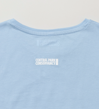 Back view of a light blue t-shirt with the Central Park Conservancy logo near the collar