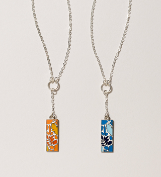 Pair of Central Park Conservancy long lariat necklaces one with a orange leaf design and one with a blue leaf design