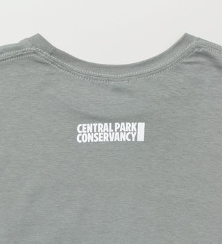 Close-up view of the back of a gray t-shirt with 'Central Park Conservancy' logo near the neckline.
