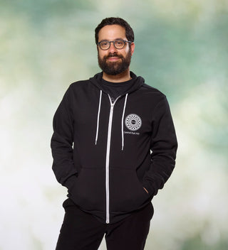 Man smiling wearing a black zipper hoodie with "Imagine" mosaic design and "Central Park NYC" text on the front