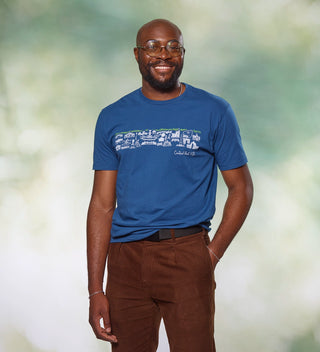 Man smiling while wearing a blue t-shirt with a Central Park line drawing design and 'Central Park NYC' text