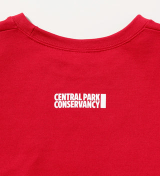 Close-up view of the back of a red sweatshirt with 'Central Park Conservancy' logo near the neckline.