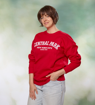 Woman posing while wearing a red "Central Park New York City" sweatshirt