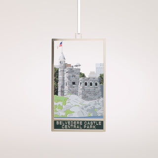 metal ornament of rendering of Belvedere Castle in Central Park hanging on a white ribbon in front of a grey background