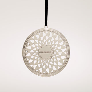 Decorative circular silver etched metal ornament with geometric pattern and 'IMAGINE' Mosaic on a gray background background