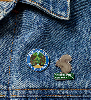 Two pins on a denim jacket: one with Central Park New York City logo and another with a squirrel design.