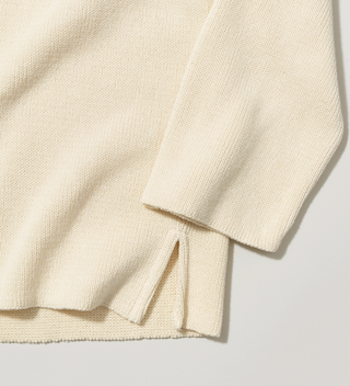 Close-up of the sleeve and hem of cream-colored "Central Park NYC" sweater 