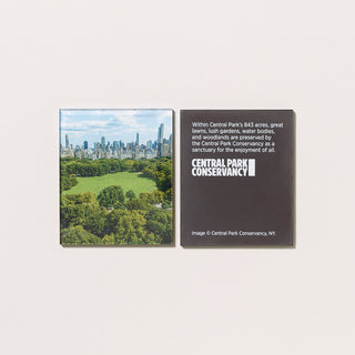 An acrylic magnet featuring a photograph of an aerial  view of Sheep Meadow in Central Park with its reverse featuring text and a logo on a gray background.