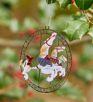 Ornament depicting the famous Central Park Carousel, with colorful horses in a brass frame. All products available through Central Park Conservancy Shop.