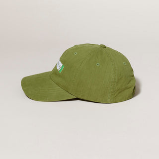 Profile of Green cap with a small part of a Central Park Conservancy  logo on a light gray background.
