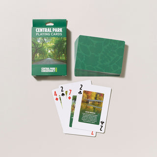 Deck of CENTRAL PARK playing cards with a duo tone green pattern on a gray background with four cards showing faces in a spread. 